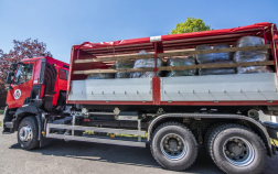 Katasztrófavédelem logóval ellátott kamion, felhajtott ponyvával, rajta a szállítmány