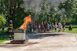 Tűzvédelmi bemutató, háttérben a táborozó gyerekekkel